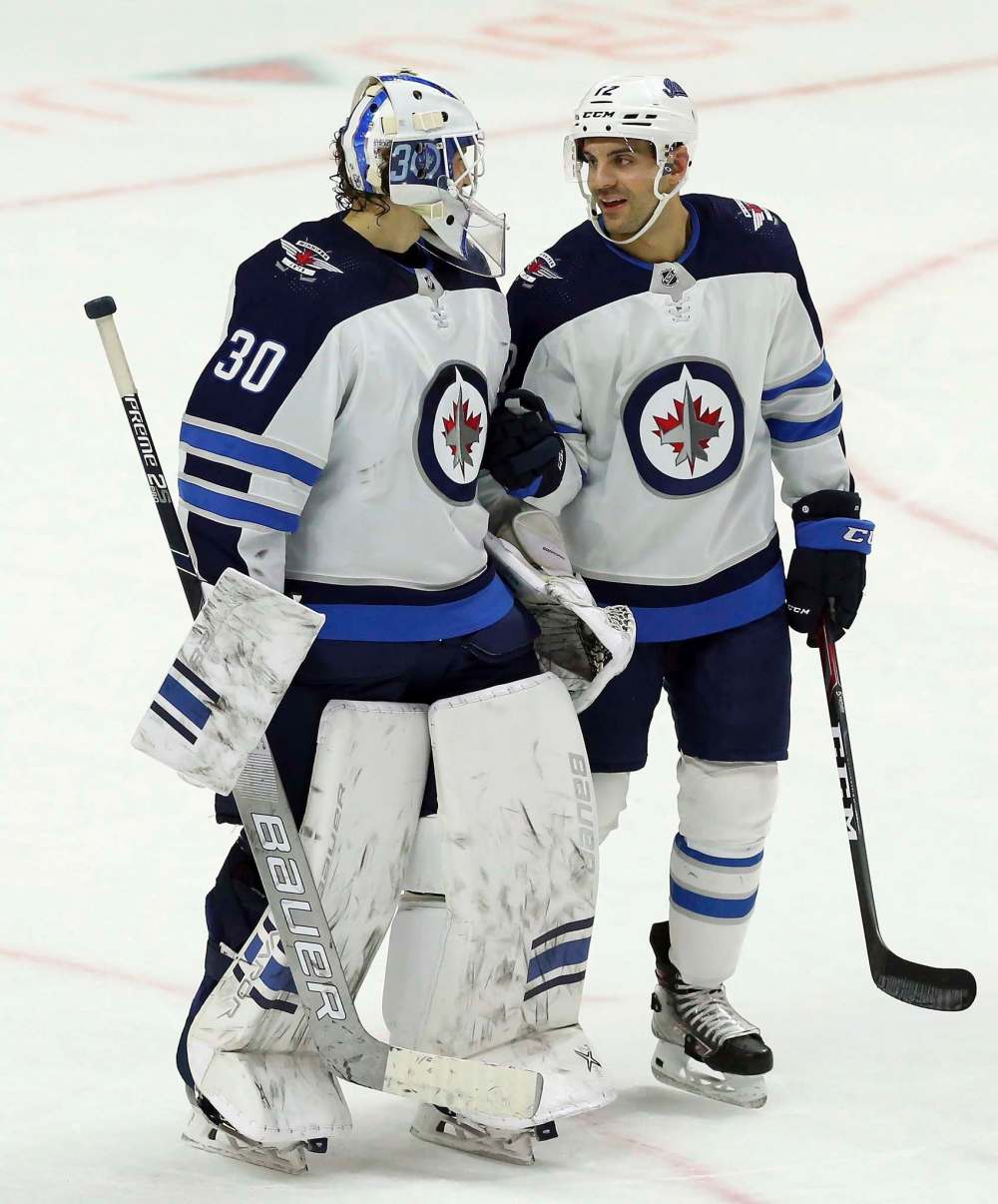 DeMelo chats with Jets goaltender Laurent Brossoit after their win. (Fred Chartrand / Winnipeg Free Press)