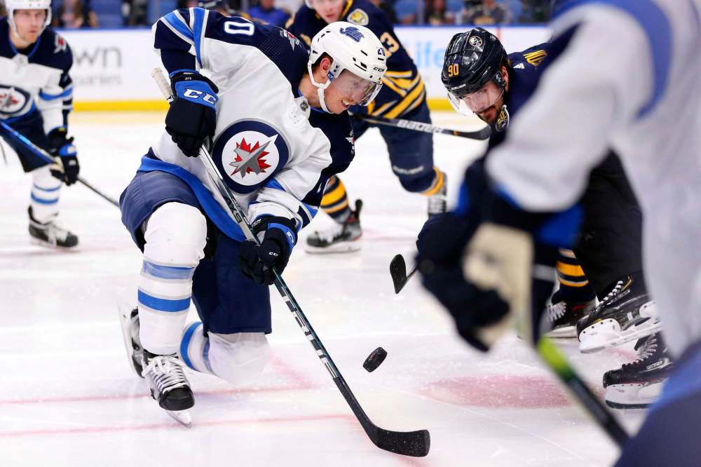 Winnipeg Jets forward Cody Eakin and Buffalo Sabres forward Marcus Johansson battle over the puck during a faceoff in the second period. (Jeffrey T. Barnes / The Associated Press)