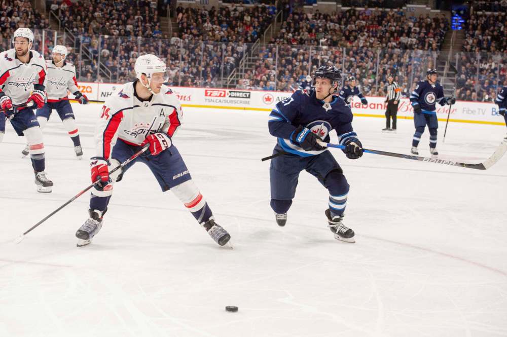 Jets Nikolaj Ehlers and Capitals John Carlson race for the puck during the second period. (Mike Sudoma / Winnipeg Free Press)