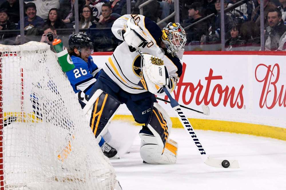 Hutton clears the puck as he is pressured by Blake Wheeler during the second period. (Fred Greenslade / The Canadian Press)