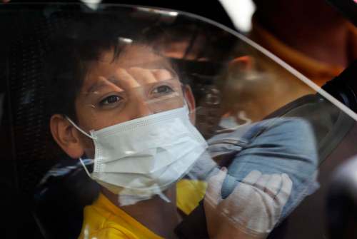 MARCO UGARTE / THE ASSOCIATED PRESS
A child wearing a surgical mask looks out a window in Mexico City Friday. Parents should provide honest, accurate information about COVID-19 and appear calm to help reassure children.