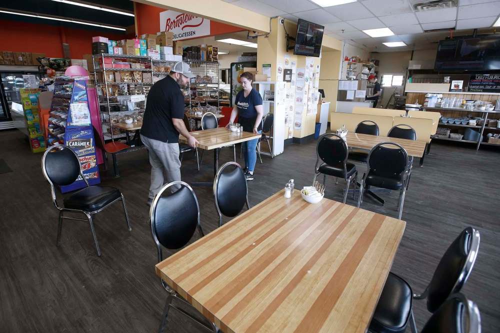 JOHN WOODS / WINNIPEG FREE PRESS
Aaron Bernstein, owner of Bernstein’s Deli, and server Allie Strom move tables to increase the distance between customers for safety reasons as the COVID-19 pandemic continues.