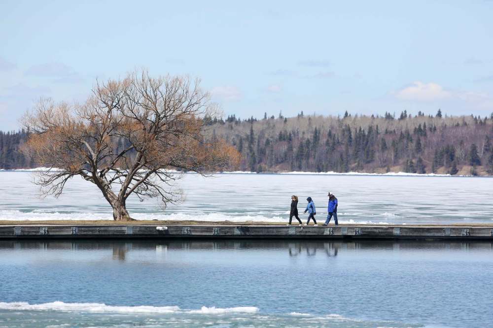 People walk along the Clear Lake Marina pier in Wasagaming on a sunny day. Spring break is usually a great time to visit the town but the pandemic is having a crippling effect on hospitality businesses there and across the province. (Tim Smith / Brandon Sun files)