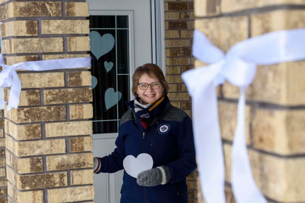 JESSE BOILY / WINNIPEG FREE PRESS
Karen Schellenberg, a pastor at Charleswood Mennonite Church, stands outside her home with her white cutout hearts in support of health care and essential workers Thursday. She is encouraging others to join the new Whiteout.