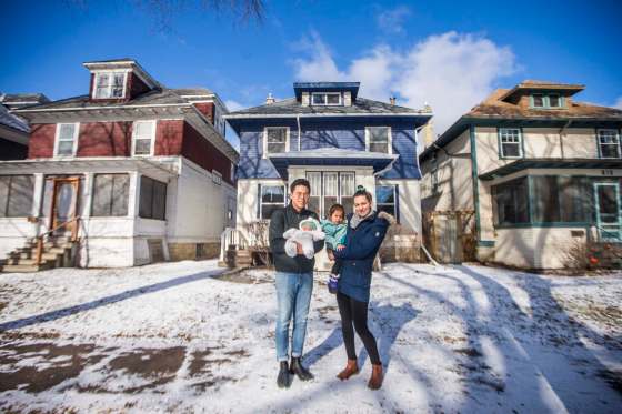 MIKAELA MACKENZIE / WINNIPEG FREE PRESS Lauren and Geung Kroeker-Lee with their two-year-old, Sula, and newborn, Lena, by their new house in Wolseley.