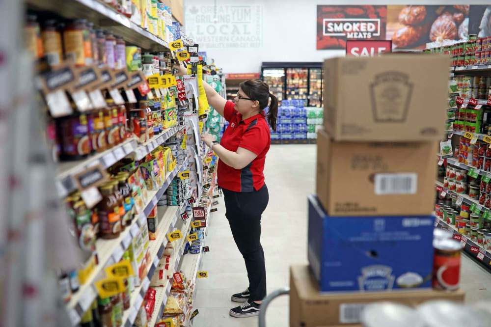 CREDIT: Tim Smith / The Brandon Sun)
An employee stocks shelves at a grocery store in Brandon. Supply chains are under stress during the pandemic, but food shortages have so far been uncommon in Canada.