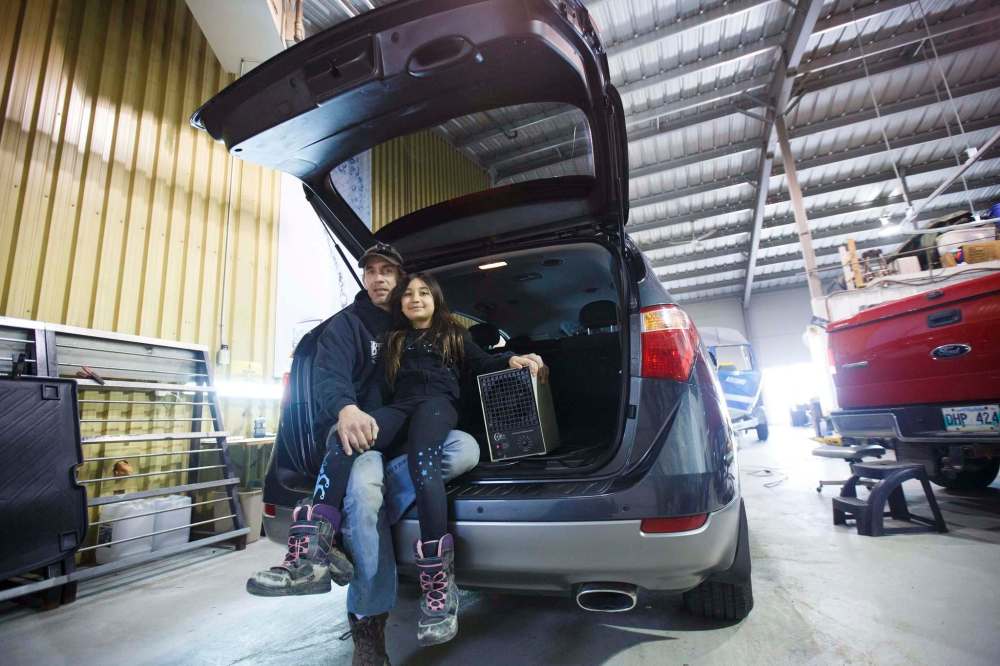 MIKE DEAL / WINNIPEG FREE PRESS
Dave Robinson, with his daughter Chloe, 7, with an air ionizer.