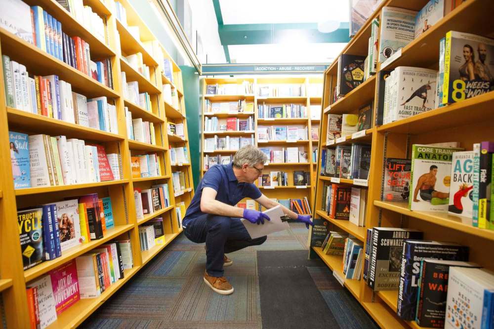 MIKE DEAL / WINNIPEG FREE PRESS
Chris Hall, co-owner of McNally Robinson, collects online book orders.