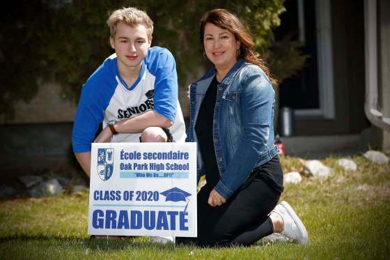 JOHN WOODS / WINNIPEG FREE PRESSOliver Spencer and his mother Sherri Brayshaw-Spencer with an Oak Park High School grad lawn sign outside their home in Winnipeg Sunday. The signs were put on the lawns of students who are graduating amid the COVID-19 pandemic.