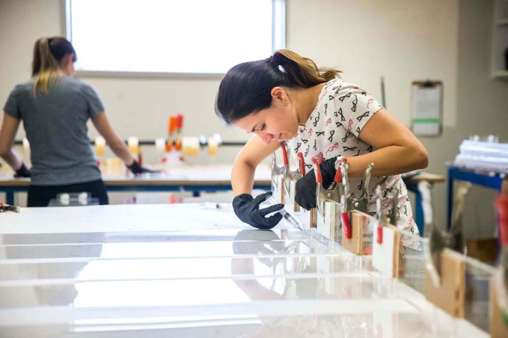 MIKAELA MACKENZIE / WINNIPEG FREE PRESS
Jeanne Diniz glues cough guard parts together at Acryl Design.