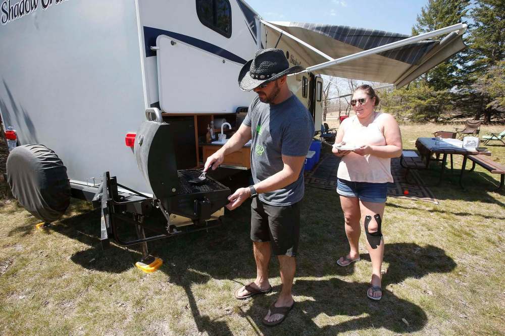 Whitney Brault and Jason Zarecki get the BBQ ready for some grilling when they were out enjoying a week of camping in Birds Hill Provincial Park just north of Winnipeg Sunday. John Woods / Winnipeg Free Press