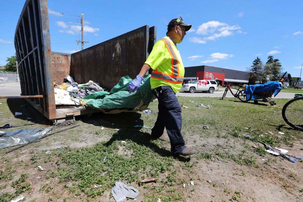 RUTH BONNEVILLE / WINNIPEG FREE PRESS
Lawrence Corbiere helps tidy the area and dump garbage into a large dumpster on the site Friday.