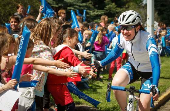 Clara Hughes is greeted by students in High River, Alta., in May 2014 during her tour across Canada to raise awareness about mental health. (Jeff McIntosh / The Canadian Press files)