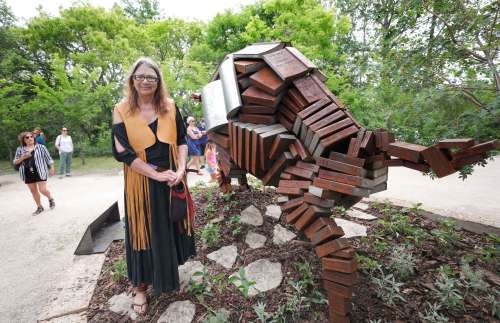 RUTH BONNEVILLE / WINNIPEG FREE PRESS
Local artist Val Vint with her new piece, Education is the New Bison, a 12-foot bison made up of 200 steel replicas of books and other articles. Each book is written by an Indigenous or allied author, most of whom are local.