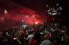 Liverpool supporters celebrate as they gather outside of Anfield Stadium in Liverpool, England on Thursday after Liverpool clinched the English Premier League title. (Jon Super / The Associated Press)