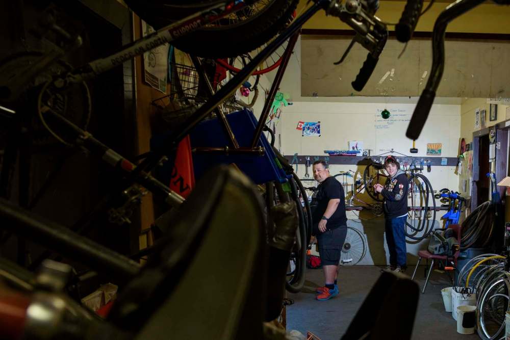 Maciejko and Charles Pearce (right), another volunteer, keep busy in the shop packed with bikes for repair. (Jesse Boily / Winnipeg Free Press)