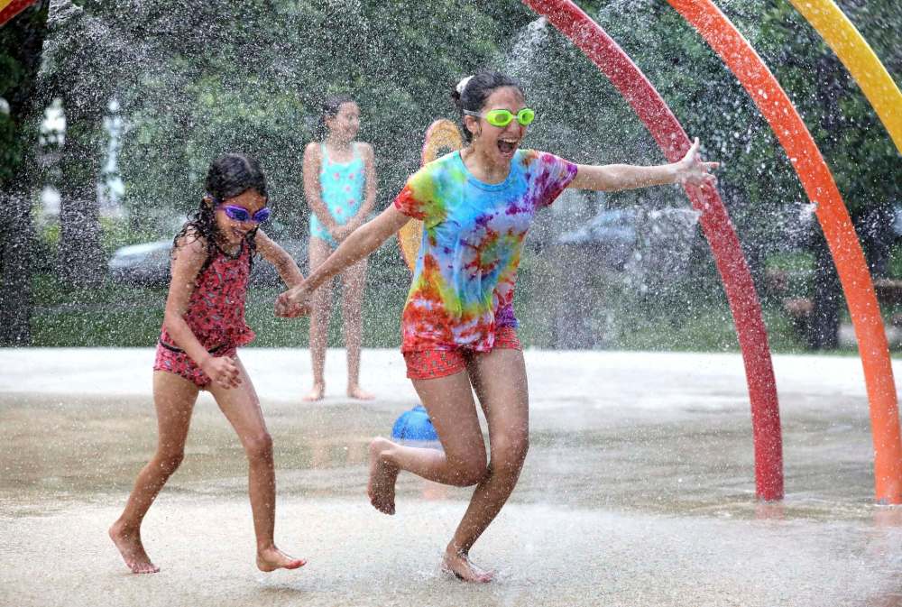 RUTH BONNEVILLE / WINNIPEG FREE PRESS
Sisters Maylis, 12, and Melanie, 7, enjoy cooling themselves at Provencher Park Spray Pad Monday.