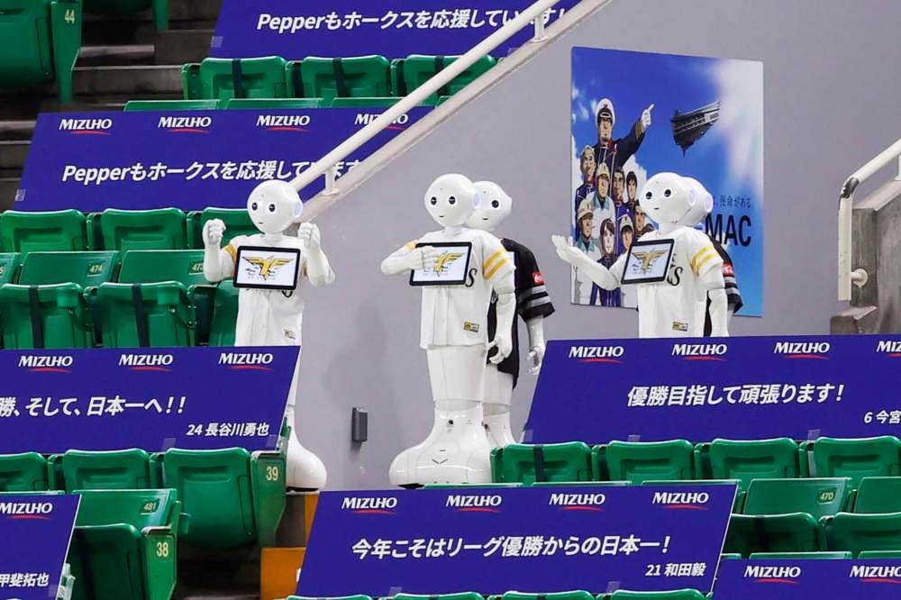 The Associated Press Files
Humanoid robot Peppers are at a stadium in Fukuoka, Japan, during a baseball game without the presence of fans because of the pandemic. Peppers are humanoid robots that exhibit body language, move around on wheels and perceive their surroundings.