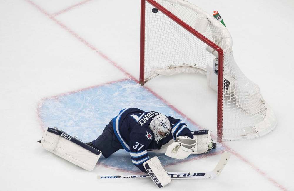 Jason Franson / The Canadian Press
The puck hits the post behind Connor Hellebuyck during the first period Tuesday.
