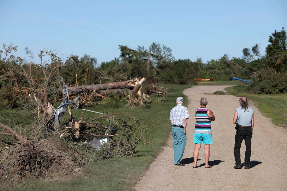 Locals residents survey the damage at Giovanni Colangelo’s farm south of Virden on Saturday following a tornado Friday night that killed two teens from Melita and injured a man from Sioux Valley Dakota First Nation. (Tim Smith / The Brandon Sun)