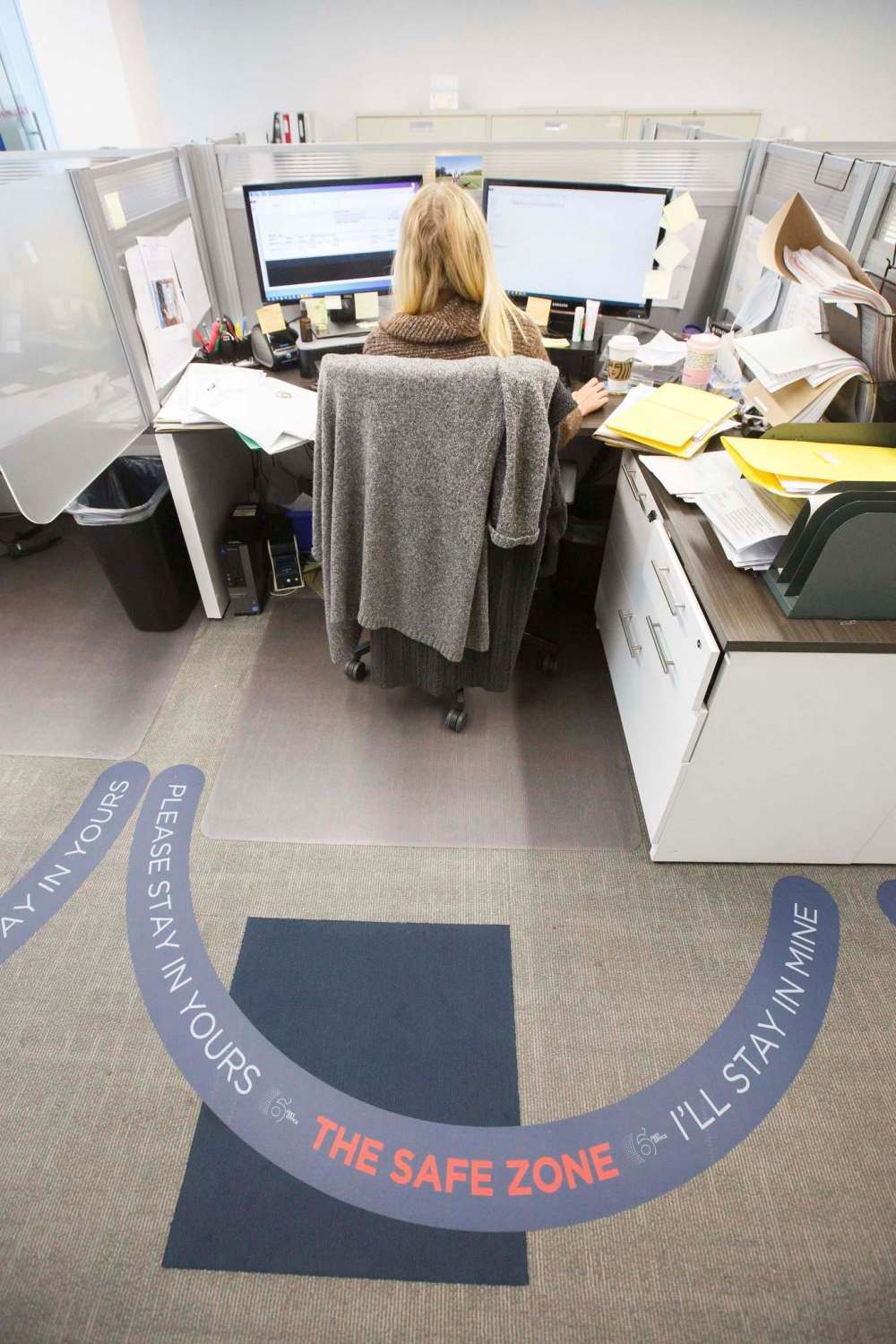 Employee workspaces are enclosed by a semi-circular arc to prevent desk-to-desk visitation. (Mike Deal / Winnipeg Free Press)