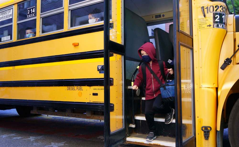 Students in Montreal wear masks on the school bus on Monday. (Paul Chiasson / The Canadian Press)
