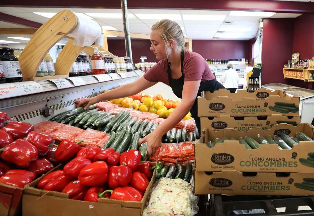 RUTH BONNEVILLE / WINNIPEG FREE PRESS
Sierra Schreimer works on a vegetable display at Vic’s Fruit Market.