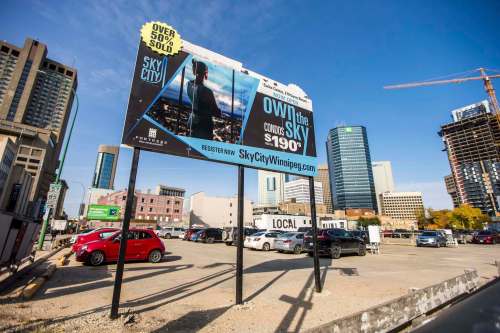 MIKAELA MACKENZIE / WINNIPEG FREE PRESS
Signage for the failed SkyCity condo development still stands in the downtown parking lot where the condos were supposed to be built. The lot is back on the market.