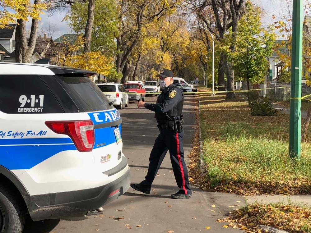 Officers investigate after a man was shot in a North End back lane by a member of the Winnipeg police. (Ruth Bonneville / Winnipeg Free Press)