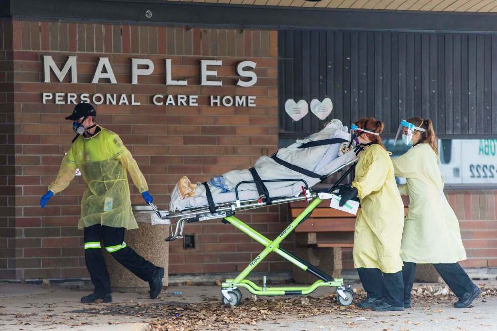 MIKAELA MACKENZIE / WINNIPEG FREE PRESS
The Stretcher Service of Manitoba wheels a gurney into the building at the Maples long term care home in Winnipeg on Monday.