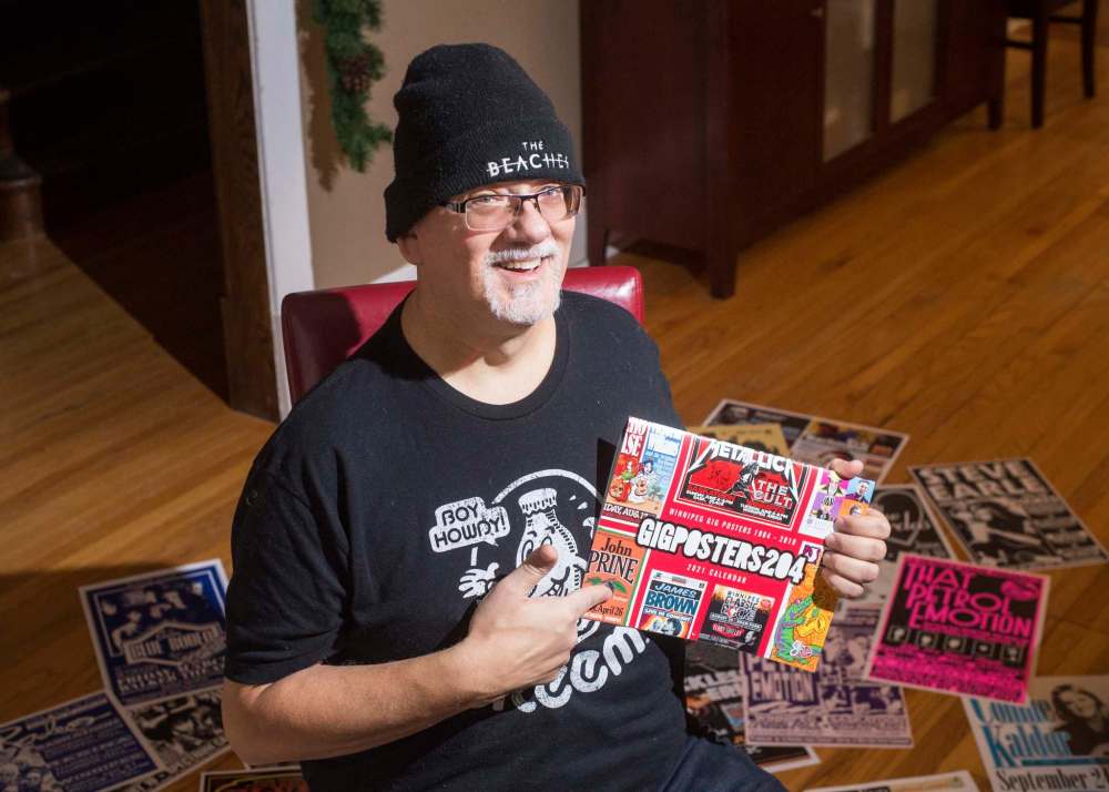 Mike Sudoma / Winnipeg Free Press
Stu Reid aka “Stu Art” holds up his newly released “Gig Posters” calendar, while being surrounded by “just a few” of the posters he’s designed over the years.