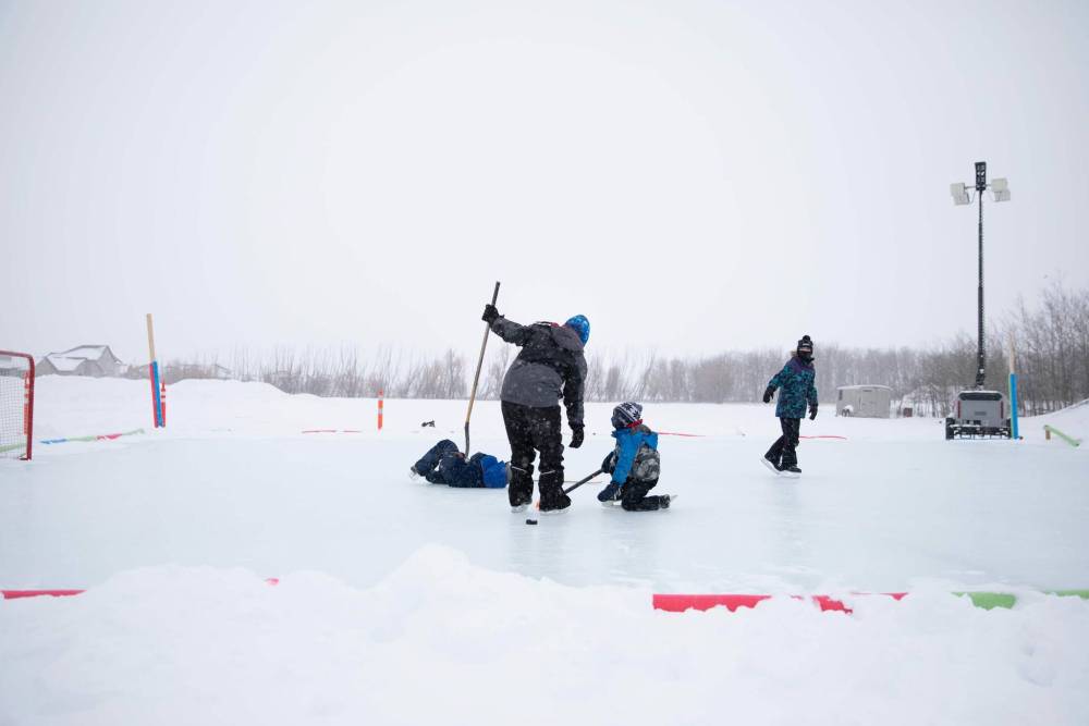 JESSICA LEE / WINNIPEG FREE PRESS Brothers Mohammed Alkhalaf, 10 (centre), Omar, 8 (left on floor), and Almutsum, 5 (right), spend January 4, 2022, morning skating at a new public rink at the Winnipeg Grand Mosque at 2445 Waverley Street.