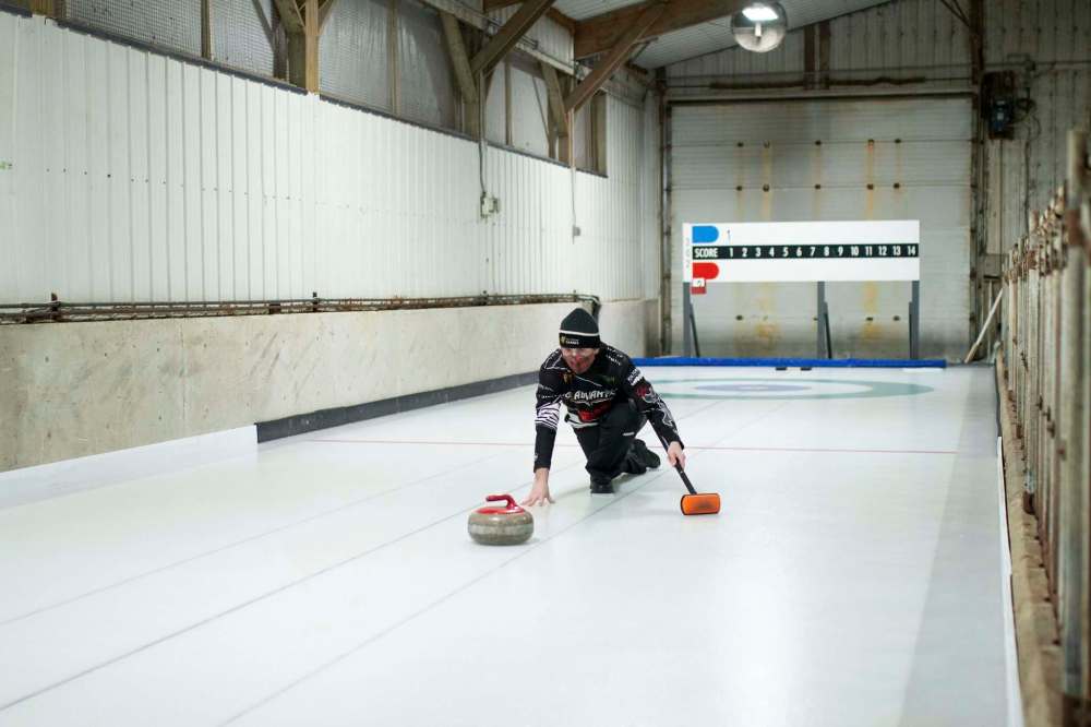 Aaron van Ryssel tests out his family’s new curling sheet built inside a storage barn on their farm. (Rosanna Hempel / Winnipeg Free Press)