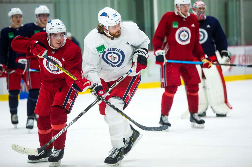 MIKAELA MACKENZIE / WINNIPEG FREE PRESS FILES
Ville Heinola (left) tangles with Jets captain Blake Wheeler during a practice at the BellMTS Iceplex in October 2019.