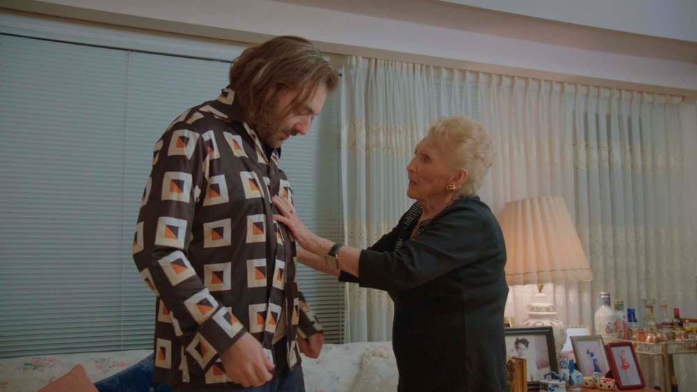 Filmmkaer Daniel Schubert is outfitted with his late grandfather’s shirt by his grandmother Martha Katz in Schubert’s NFB documentary Martha. Photo courtesyt of National Film Board.