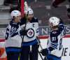 Winnipeg Jets' Mark Scheifele, left, and Kyle Connor, right, congratulate Blake Wheeler on his goal during second period NHL action against the Ottawa Senators on Thursday. THE CANADIAN PRESS/Adrian Wyld