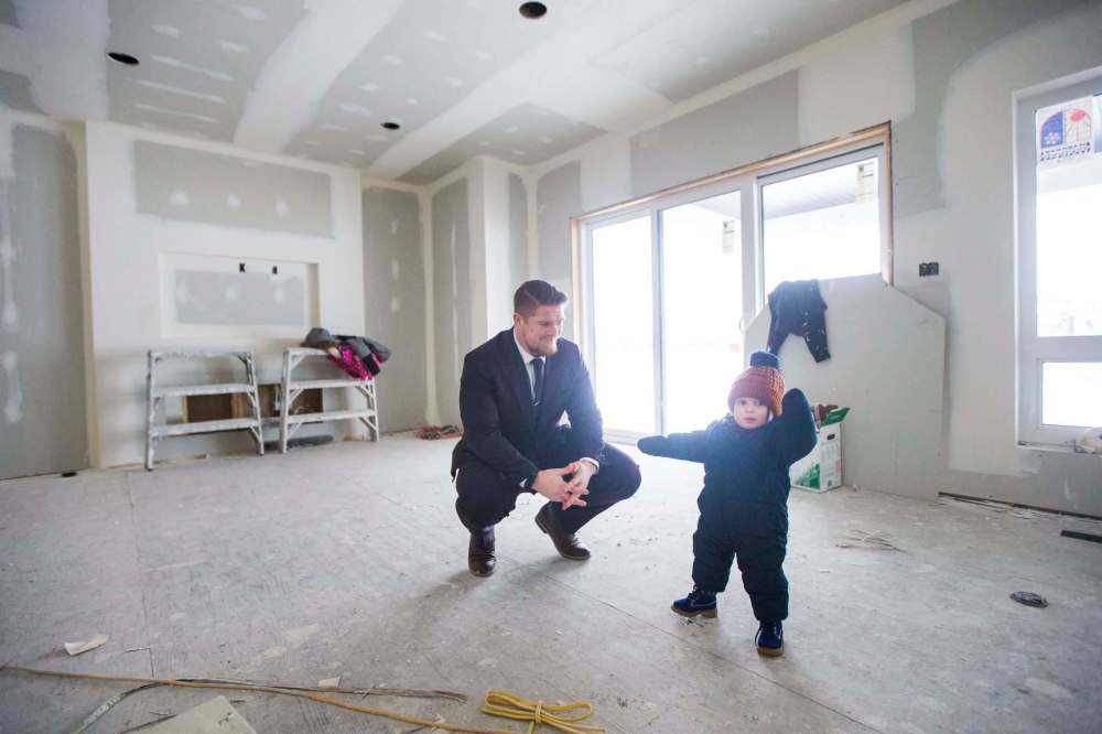 MIKAELA MACKENZIE / WINNIPEG FREE PRESS
Winnipeg Blue Bombers linebacker Adam Bighill and his son, Beau, check out the new home they're building in Bridgwater in Winnipeg on Friday.