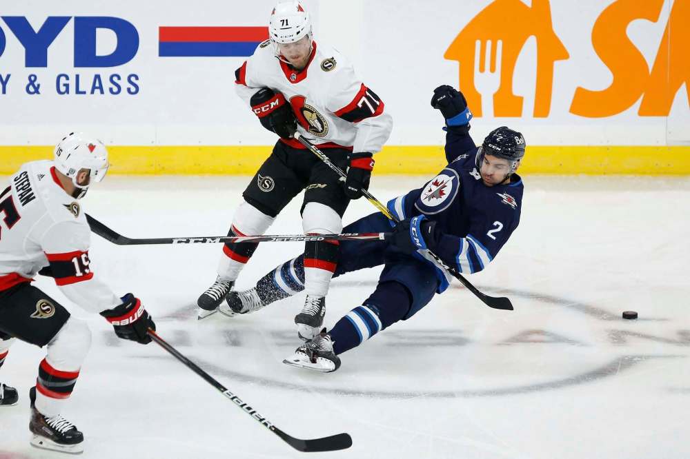 John Woods / The Canadian Press
Jets defenceman Dylan DeMelo, playing in his first game of the season, collides with Ottawa Senators forward Chris Tierney at Bell MTS Place Saturday.