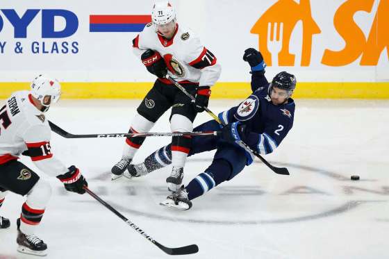 John Woods / The Canadian PressJets defenceman Dylan DeMelo, playing in his first game of the season, collides with Ottawa Senators forward Chris Tierney at Bell MTS Place Saturday.