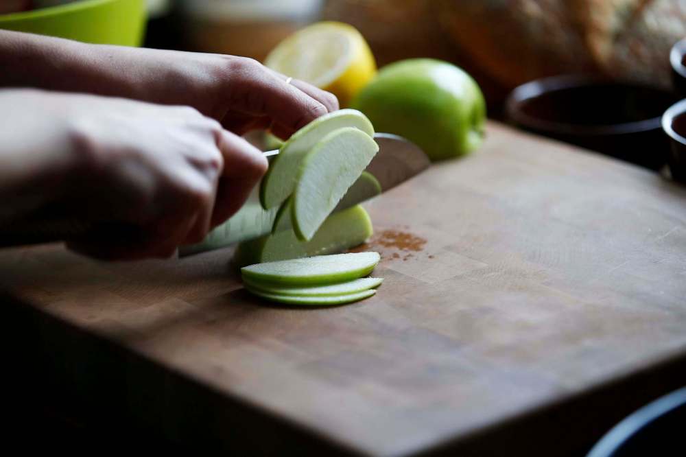 Emily Butcher prepares a panzanella in her home. (John Woods / Winnipeg Free Press)