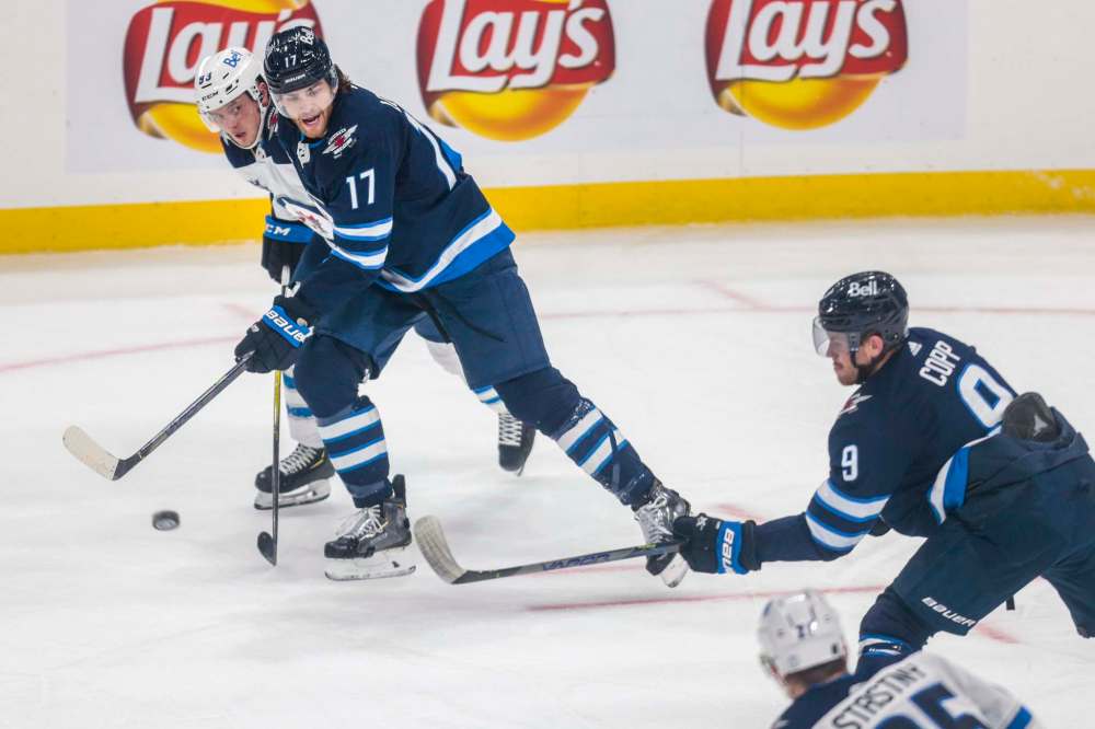 Adam Lowry (left) has been on a tear. He is on a six-game points streak heading into tonight’s game vs. the Flames. (Mikaela MacKenzie / Winnipeg Free Press files)