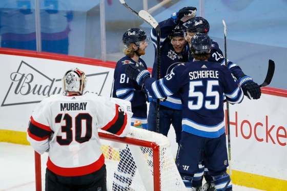 Winnipeg Jets' Kyle Connor (81), Paul Stastny (25), Blake Wheeler (26) and Mark Scheifele (55) celebrate Wheeler's goal against Ottawa Senators goaltender Matt Murray (30) during second period NHL action in Winnipeg on Thursday, February 11, 2021. THE CANADIAN PRESS/John Woods
