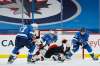 Winnipeg Jets goaltender Connor Hellebuyck (37) keeps his eye on the puck as Ottawa Senators' Evgenii Dadonov (63) tries to get a shot away and Jets' Adam Lowry (17) and Derek Forbort (24) defend during second period NHL action in Winnipeg on Saturday, February 13, 2021. THE CANADIAN PRESS/John Woods