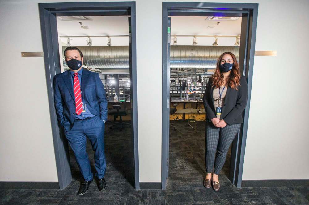Kyle Balharry, Winnipeg Jets senior director of game presentation (left), and Priya Plested, controller of crowd noises, at the doors of their booths before a Jets game earlier this month. (Mikaela MacKenzie / Winnipeg Free Press)