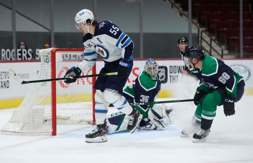 Winnipeg Jets' Mark Scheifele scores the game-winnipeg goal against Vancouver Canucks' Thatcher Demko with Nate Schmidt trailing during the first period in Vancouver, Friday. (TREVOR HAGAN / WINNIPEG FREE PRESS)