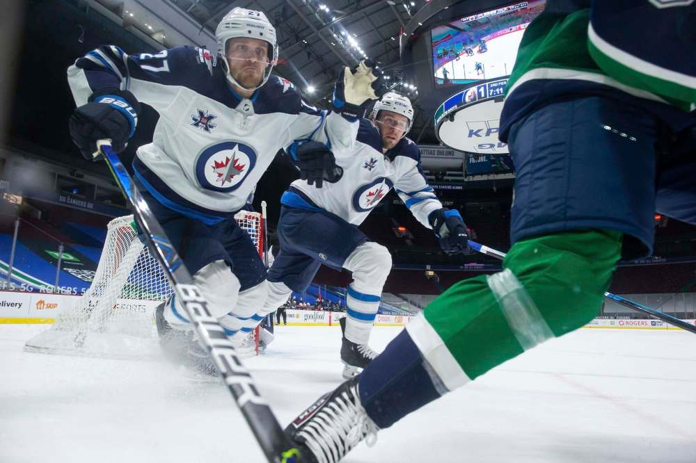 Winnipeg Jets' Nikolaj Ehlers (27) and Tucker Poolman (3) chase down Vancouver Canucks' Brock Boeser during the third period of an NHL hockey game in Vancouver on Friday. “We’re competitive guys. There’s always some kind of competition between everyone,