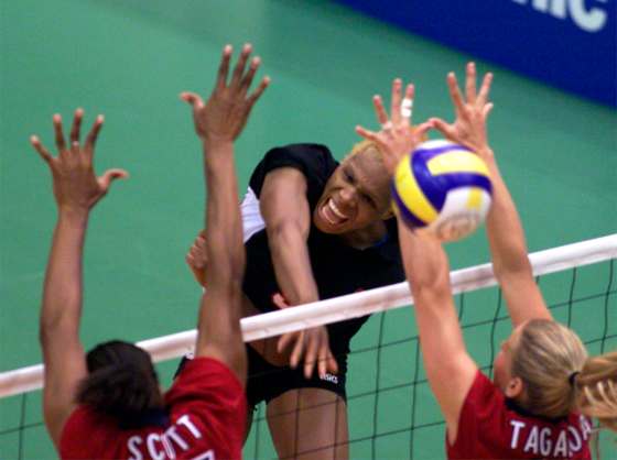 Janis Kelly drives a spike between U.S.A. players during women's volleyball match at the Pan Am Games in Winnipeg, in 1999. (CP PHOTO/Pierre Obendrauf)