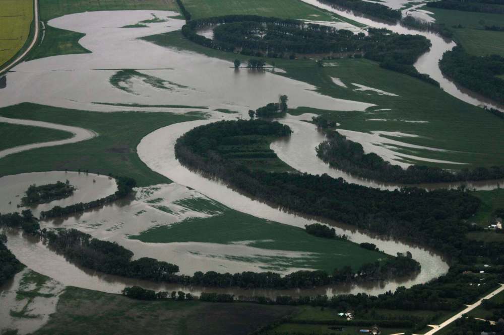 Heavy rains in western Manitoba and Saskatchewan recently have raised the level of the Assiniboine River causing it to overflow its banks flooding roads and farmers fields. Aerial photo's east of Portage la Prairie area. July 08, 2014 Ruth Bonneville / Winnipeg Free Press