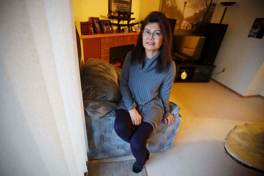 Mely Dela Cruz, a home care aide for 15 years, asks clients questions to screen for COVID-19 before she enters their homes. (John Woods / Winnipeg Free Press)