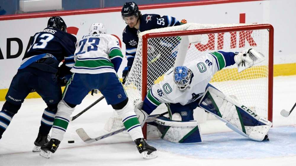 Vancouver Canucks goaltender Thatcher Demko makes a save on Winnipeg Jets' Pierre-Luc Dubois as Canucks' Alexander Edler defends during the first period in Winnipeg on Monday. THE CANADIAN PRESS/Fred Greenslade